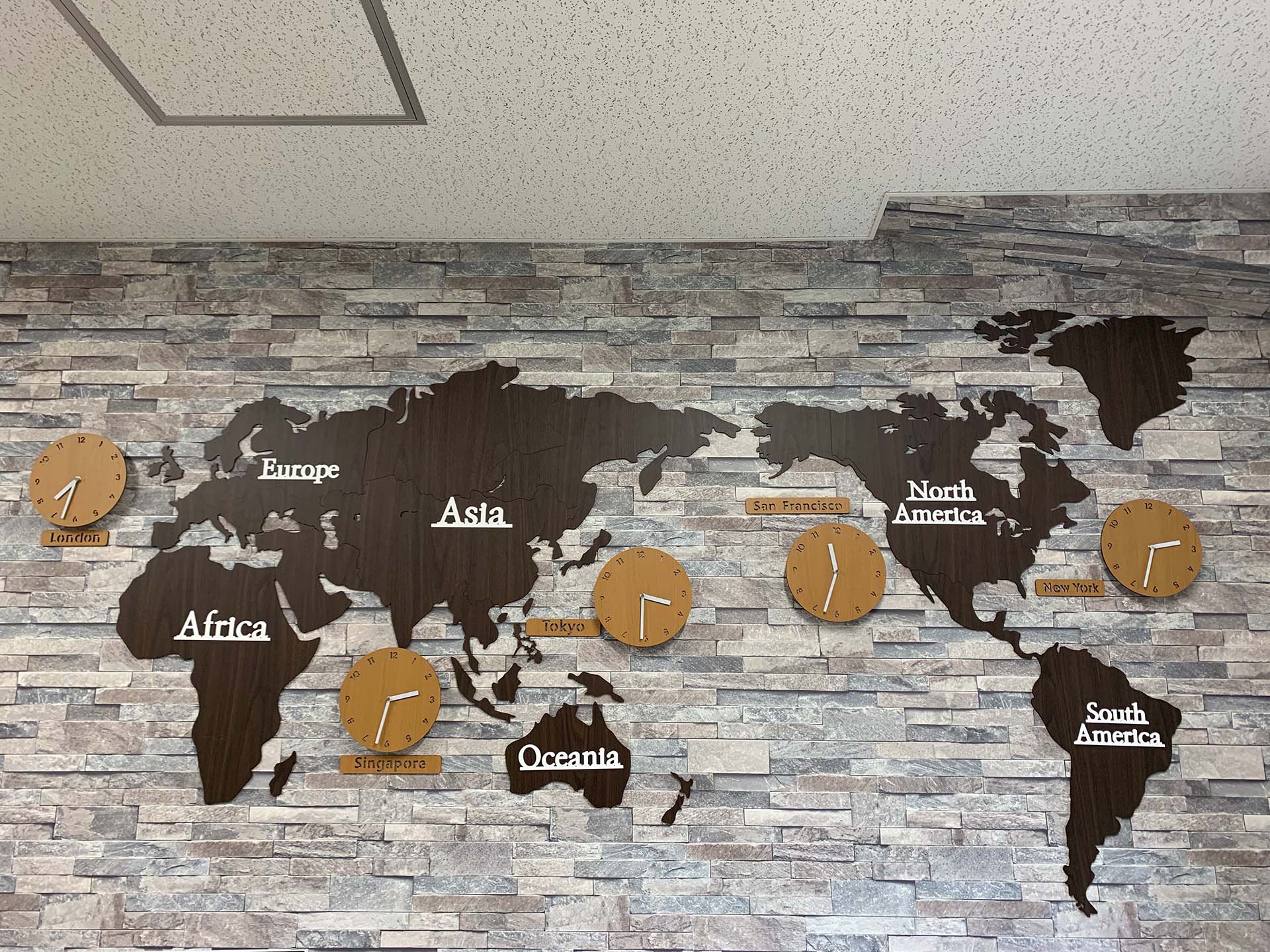 オフィスの壁には主要国の時計が並ぶ